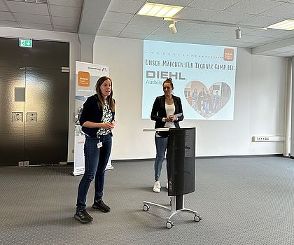 Zwei Frauen stehen im Raum und führen ein Gespräch