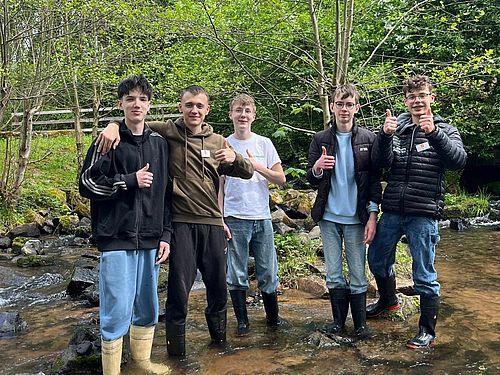 Technik-trifft-Umwelt-Camp in der MINT-Region Untermain 5 Jungen stehen im Bachlauf und probieren die Funktion ihres Papp-Wasserrads aus