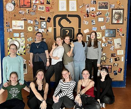 Man sieht die 12 Mädchen wie sie vor dem Logo des Escape Rooms posen.