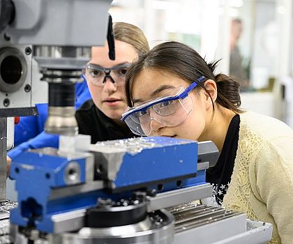 2 Mädchen begutachten den Bohrkopf der Standbohrmaschine