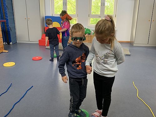 Auf dem Foto sind Kinder zu sehen, die mit Hilfe einer Simulationsbrille Farben wahrnehmen können.
