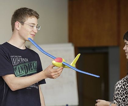 2 Jugendliche präsentieren ihr bionisches Experiment mit einem Flugzeug aus Styropor.  