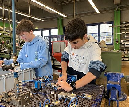 Zwei Jungen beschäftigen sich mit Luftdruck-Bauteilen.
