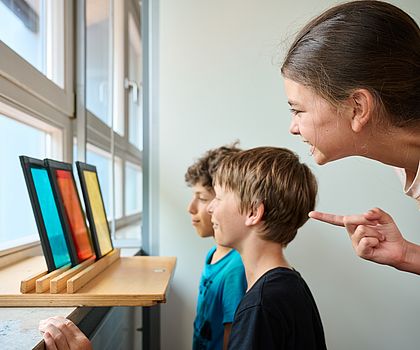 Kinder betrachten farbige Glasscheiben