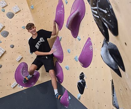 Ein Junge klettert die Kletterwand hoch