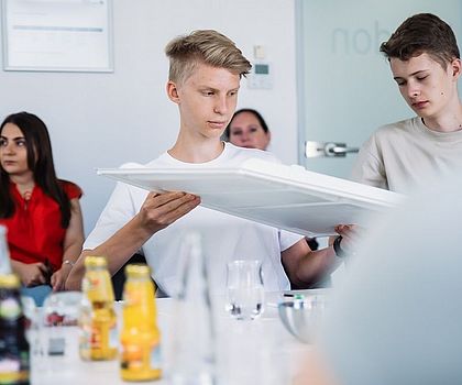 2 Jungen schauen sich verschiedene Produkte aus Plastik an