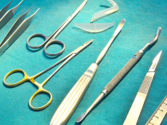 Auf einem grünen Untergrund liegen verschiedene chirurgische Werkzeuge