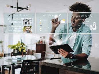 ein dunkelhätiger Mann hält ein Tablet in der Hand. Um ihn herum erscheinen KI generierte Symbole