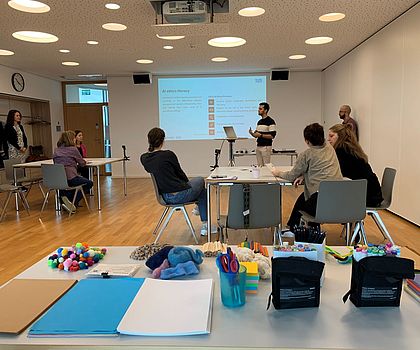 das Foto zeigt einen Seminarraum mit einem Vortragenden und Teilnehmern