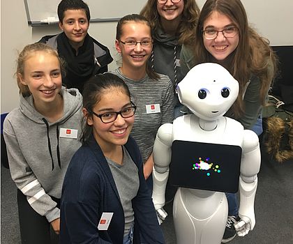 Junge Menschen machen zusammen ein Bild mit dem Roboter Pepper