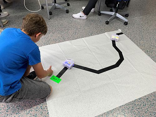 Schüler testet Roboter auf Teststrecke