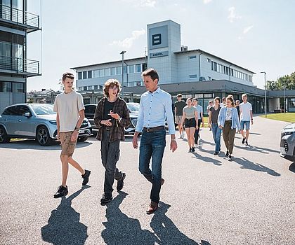 Ein Gruppe von Jugendlichen machen eine Rundgang auf dem Werksgelände