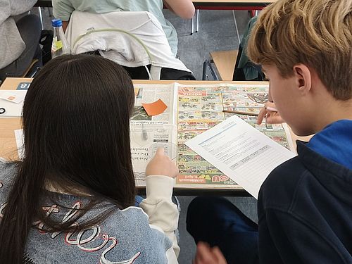 Ein Jugne und ein Mädchen führen ein Experiment mit Wasser und einer Petrischale durch.