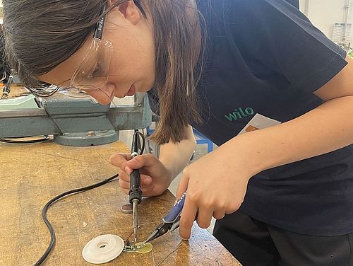 Ein Mädchen lötet die Elektronik zusammen