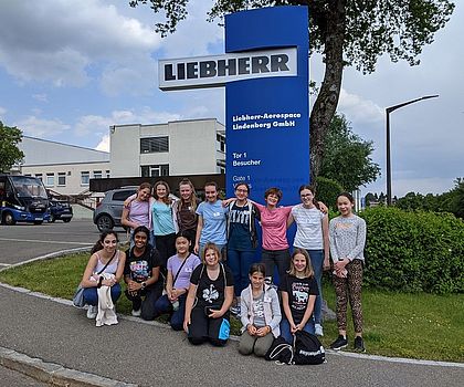 Gruppenbild vor Liebherr-Logo