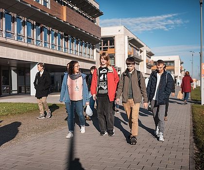 Ein Gruppe von Jugendlichen spaziert über ein Firmengelände